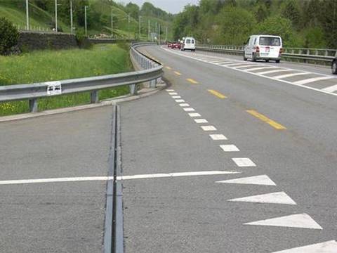 Many cars are passing through on highway that is constructed with strip seal expansion joints.