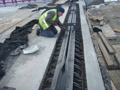 A worker is installing the strip seal expansion joints in the bridge.
