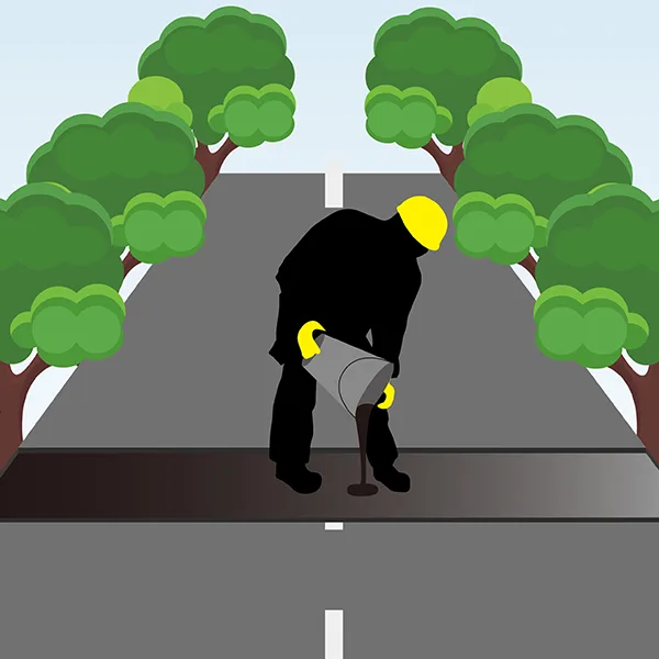 The worker pours asphalt from a bucket for laying.