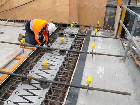 A worker is setting the finger expansion joint in the connection of bridges.